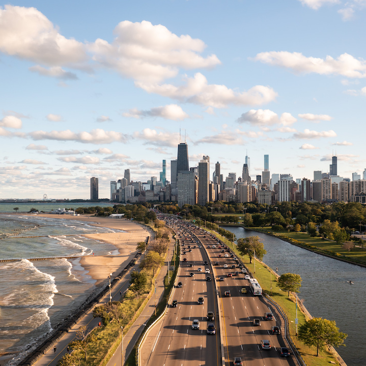 Image caption: Aerial view of DuSable Lake Shore Drive traveling along Lake Michigan with the Chicago skyline in the background.